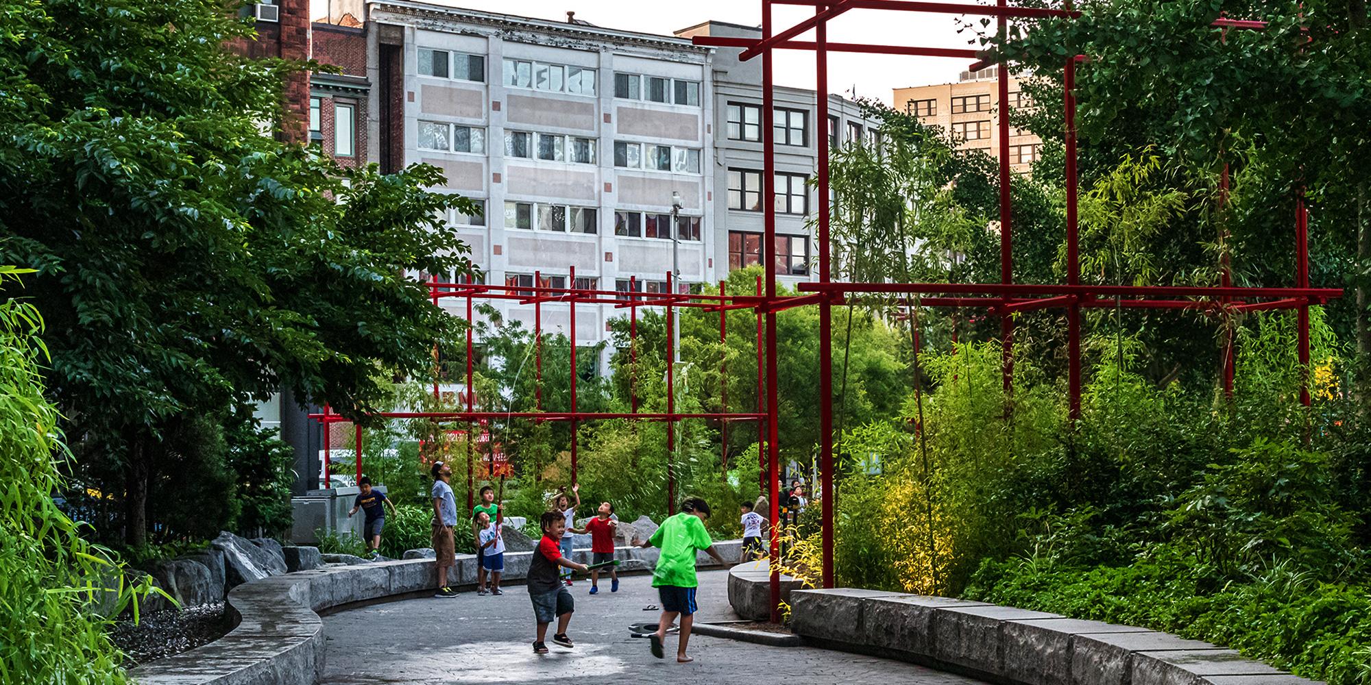 Children playing with water hose in Chinatown park